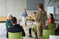 A diverse group of business professionals sits attentively in a modern office, actively - PhotoDune Item for Sale