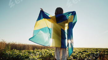 Swedish little kid - patriot child boy jumps with national flag on sky sunset background