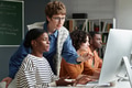 Teacher Helping Diverse Group of Students in Classroom - PhotoDune Item for Sale