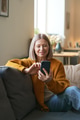Mature Woman Holding Smartphone Sitting on Couch - PhotoDune Item for Sale