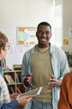 Smiling Young Man Interacting With Coworkers in Office - PhotoDune Item for Sale