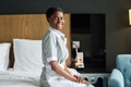 Chambermaid Wearing Uniform Sitting on Bed in Hotel Room - PhotoDune Item for Sale