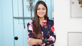 Smiling Woman with Floral Dress Standing by Blue Door - PhotoDune Item for Sale