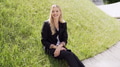 Smiling Woman in Black Suit Sitting on Green Grass - PhotoDune Item for Sale