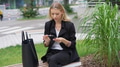 Professional Woman Checking Phone on City Bench - PhotoDune Item for Sale