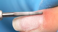 Manicurist in process of removing gel polish or acrylic from nails using manicure machine. - PhotoDune Item for Sale