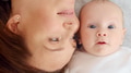 Happy newborn baby with his mother. Healthy newborn baby in a white t-shirt with mom. - PhotoDune Item for Sale