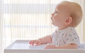 Cute baby is sitting on a high chair waiting for a meal. - PhotoDune Item for Sale
