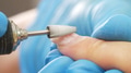 Manicurist in process of removing gel polish or acrylic from nails using manicure machine. - PhotoDune Item for Sale