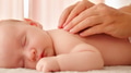 Mother doing massage on her healthy sleeping infant baby. - PhotoDune Item for Sale