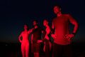 Diverse Athletes Unwind: Post-Marathon Rest Under Red Nighttime Glow. - PhotoDune Item for Sale