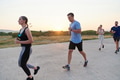 A diverse group of runners trains together at sunset. - PhotoDune Item for Sale