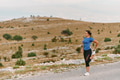 Determined Female Athlete Stretching After an Intense Run Through Rugged Mountain Terrain. - PhotoDune Item for Sale