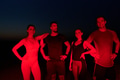 Diverse Athletes Unwind: Post-Marathon Rest Under Red Nighttime Glow. - PhotoDune Item for Sale